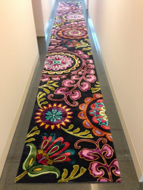 Long, bright little rug in the hallway
